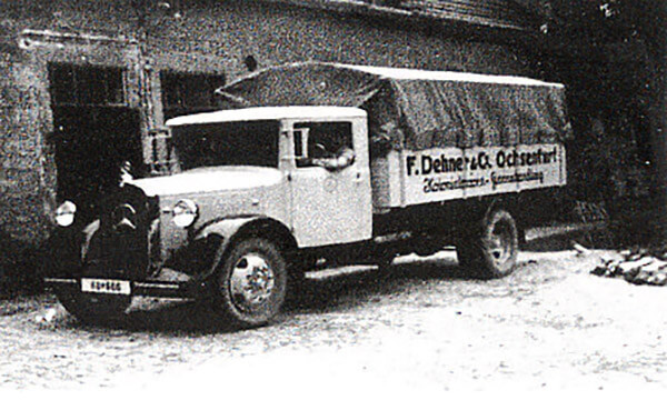 Historische Schwarzweißaufnahme eines Lieferwagens der Firma „F. Dehner & Co., Ochsenfurt" (Kolonialwaren- und Samenkandlung) vor einem Gebäude, vermutlich 1930er bis 1950er Jahre.